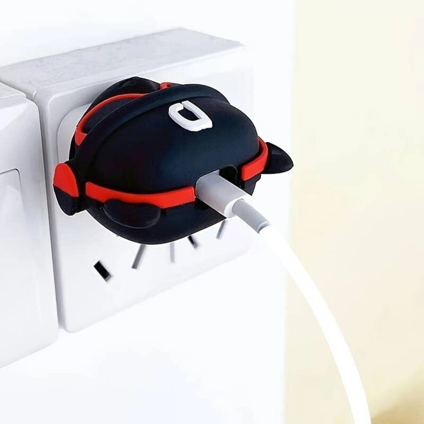 Black DJ character charger cover and mini cable protector set on white charging dock on desk