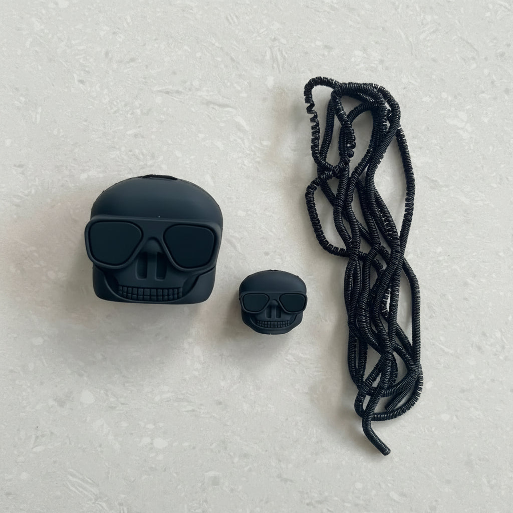 Skull AirPods case and mini skull cable protector with lanyard on marble background
