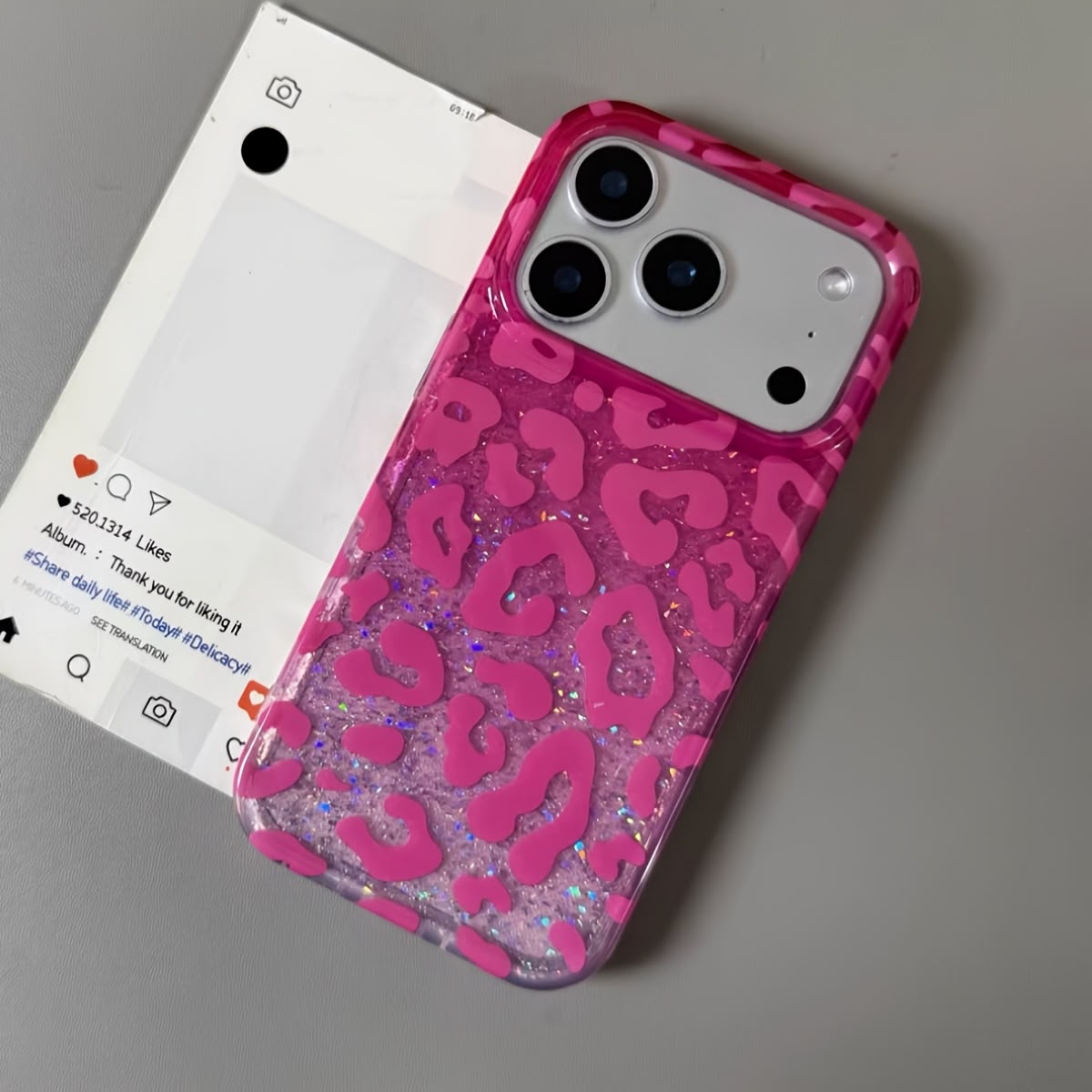 Hot pink leopard glitter iPhone case against punk poster wall