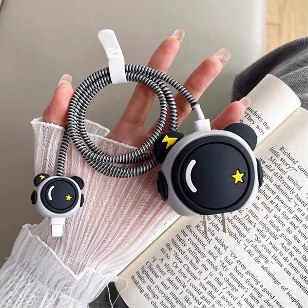 Cute panda face charger cover and cable winder held near book