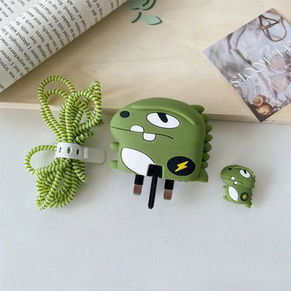 Dino monster charger set flat lay - adapter cover, cable bite protector and green coil winder