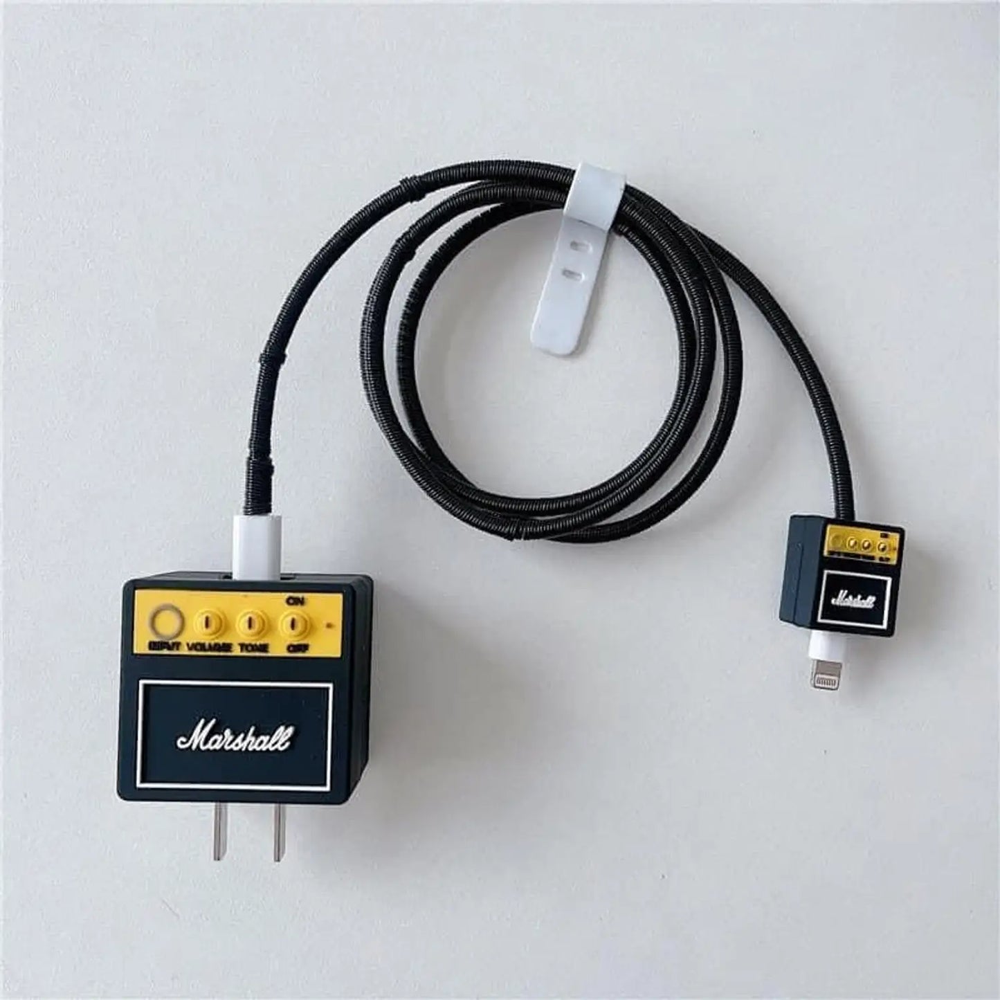 Rock amp charger adapter cover and mini amp cable bite with black coil winder - product flat lay on white background