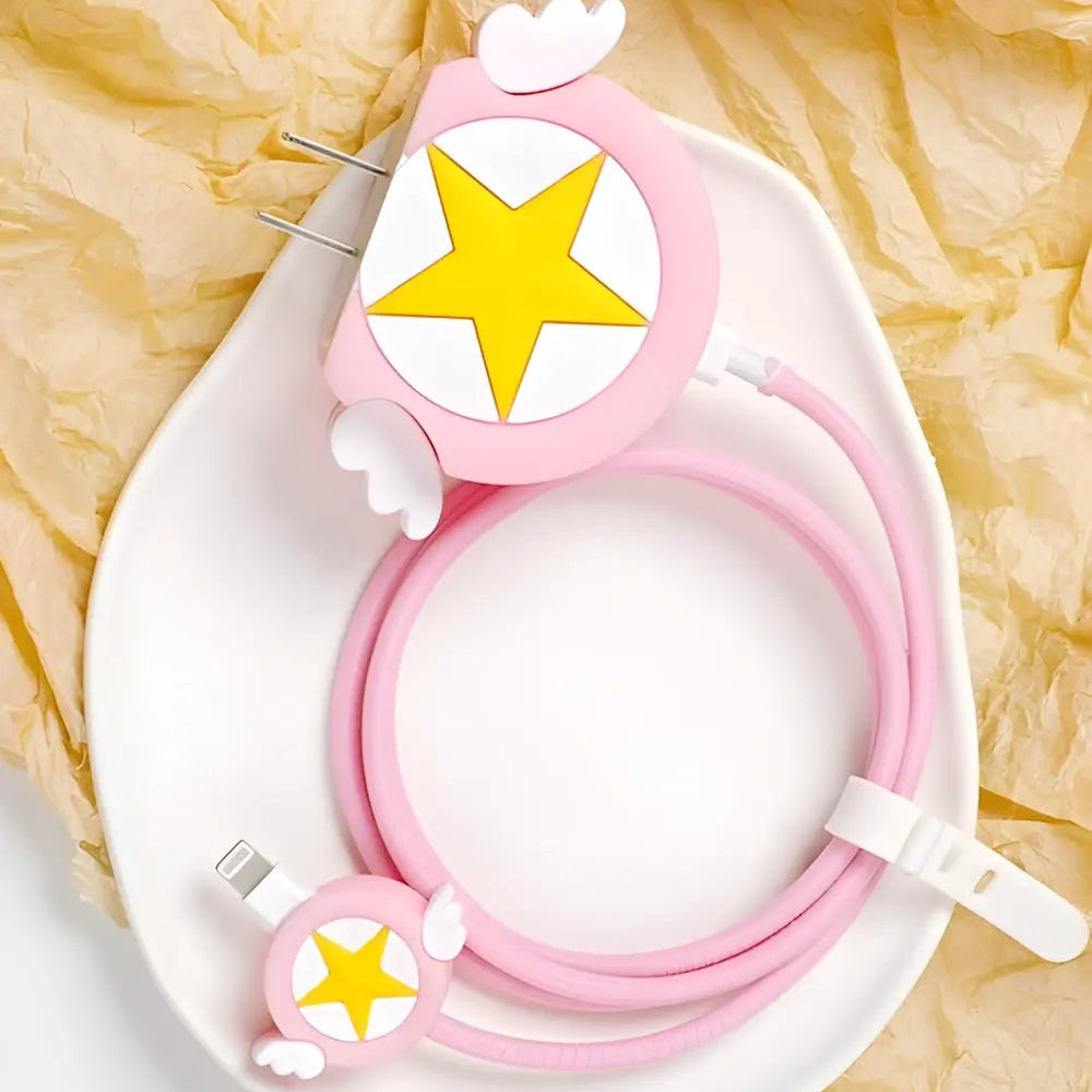 Pink winged star charger cover and mini cable protector with pink spiral cable wrap flat lay on white surface next to pink bowl
