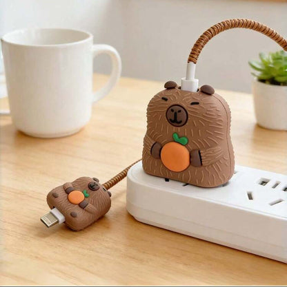 Capybara charger adapter cover on power strip with golden coil winder - close up lifestyle shot