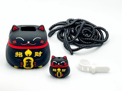Black fortune cat charger cover and mini fortune cat cable protector with black spiral cable wrap on white surface
