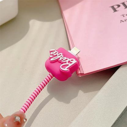 Hot pink script logo cable protector close-up on pink spiral cable with pink book background