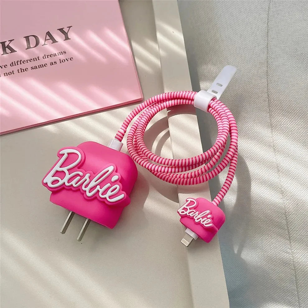 Hot pink silicone charger cover and spiral cable wrap flat lay on white fabric with pink book