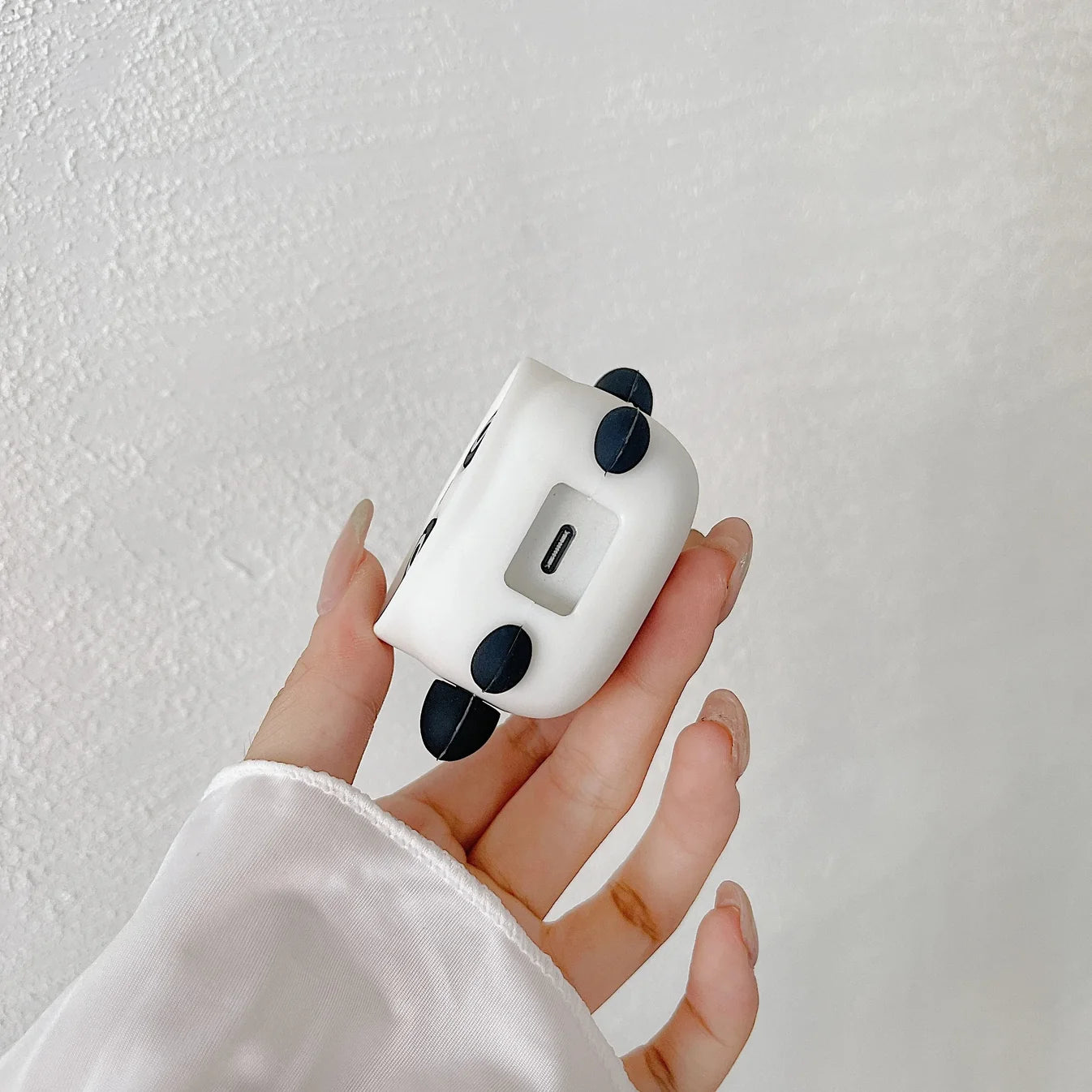 Panda face charger cover, mini panda cable protector and white spiral cable wrap components on grey surface
