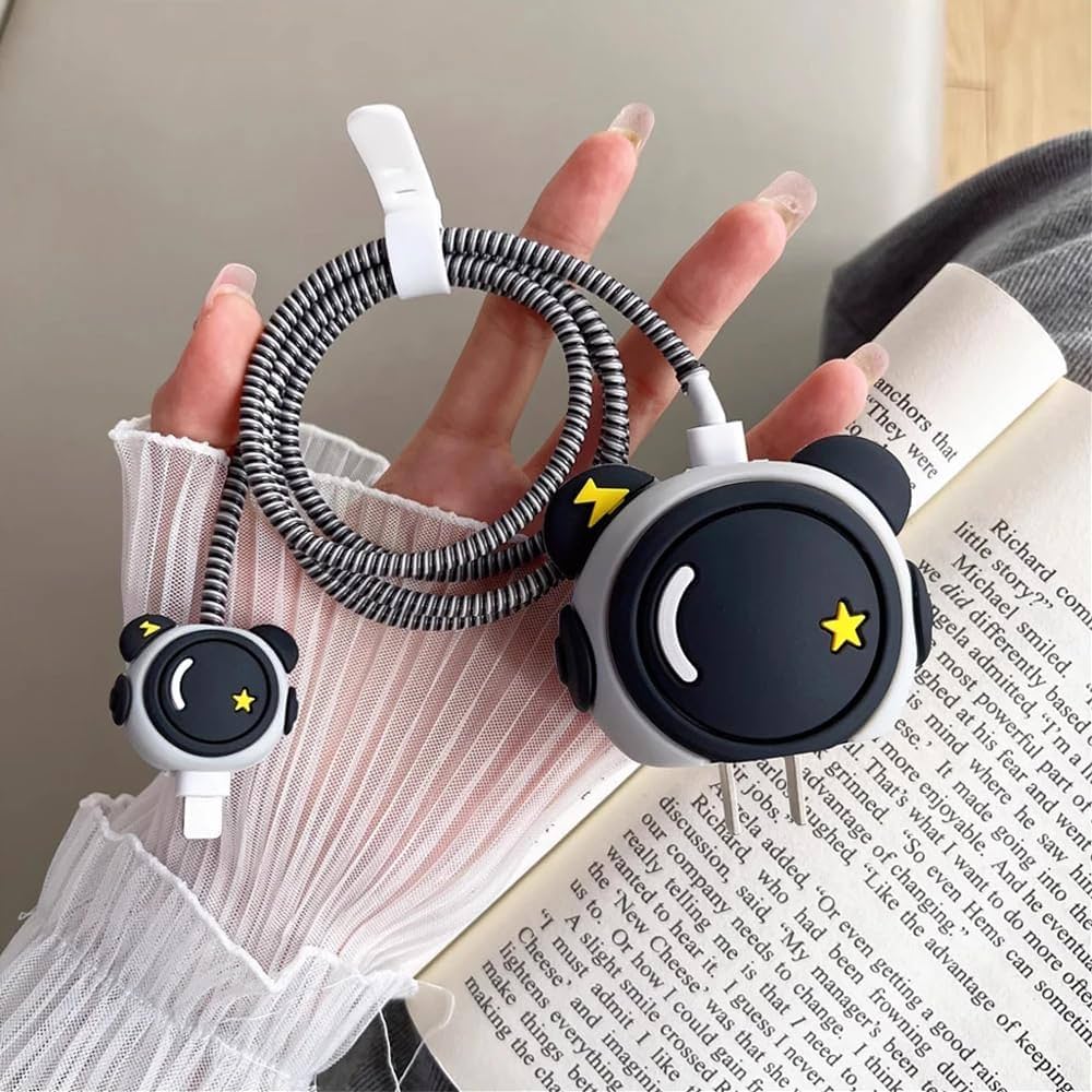 Cute panda face charger cover and cable winder held near book