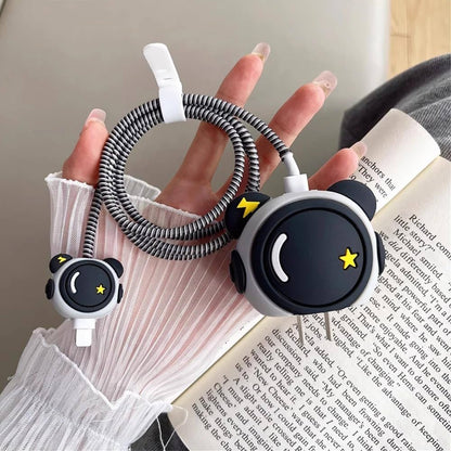 Cute panda face charger cover and cable winder held near book