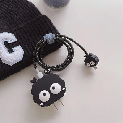 Black fluffy spirit charger cover and mini spirit cable protector with black spiral cable wrap on white surface next to black cap
