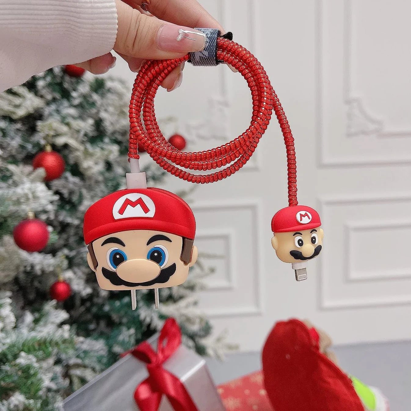 Yellow cartoon character charger cover and cable protector set held in hand with festive sweater background