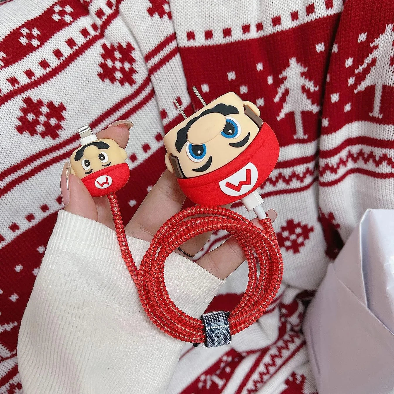 Red cartoon character charger adapter cover with red spiral cable and cable protector on white surface