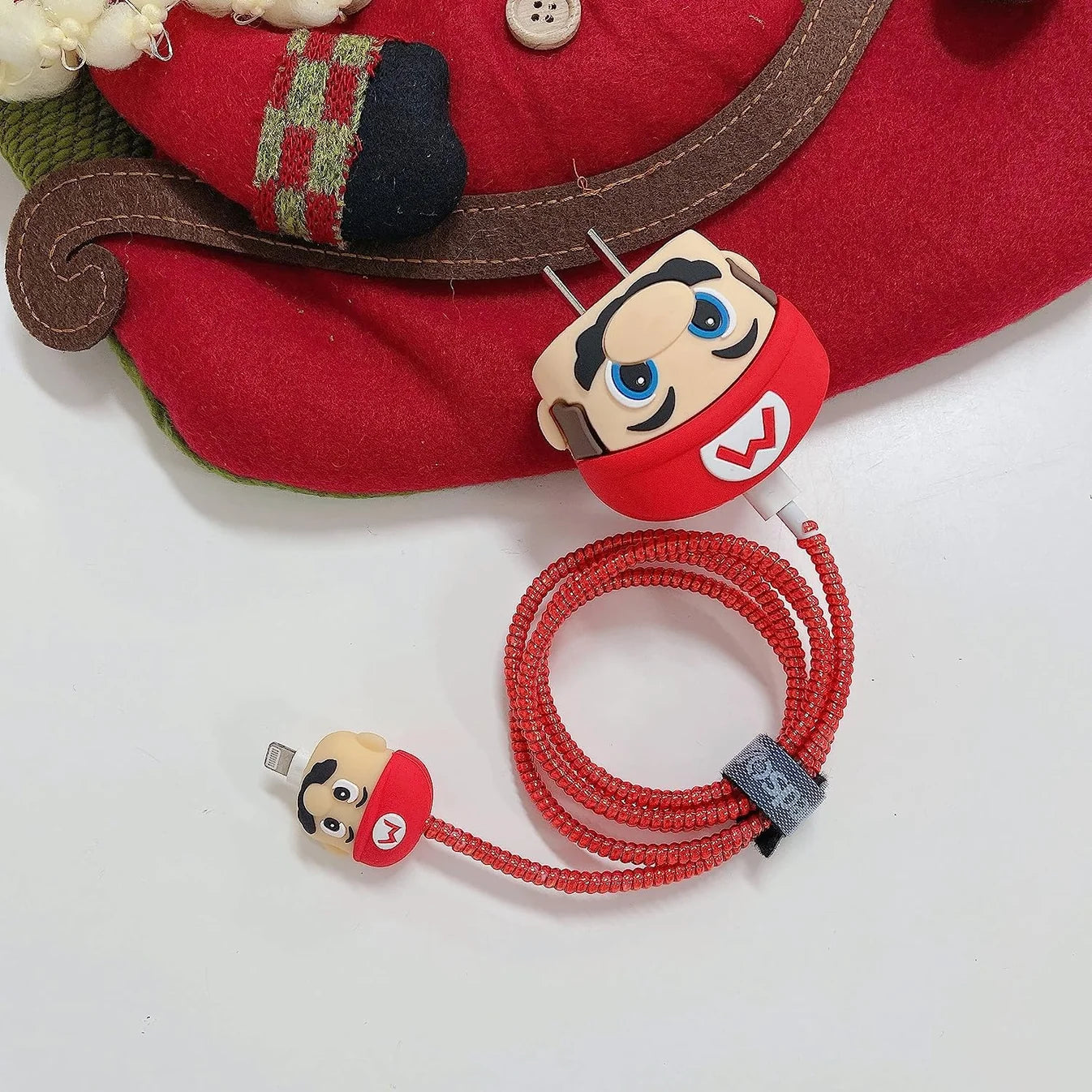 Red cartoon character charger cover with red spiral cable and mini cable protector flat lay