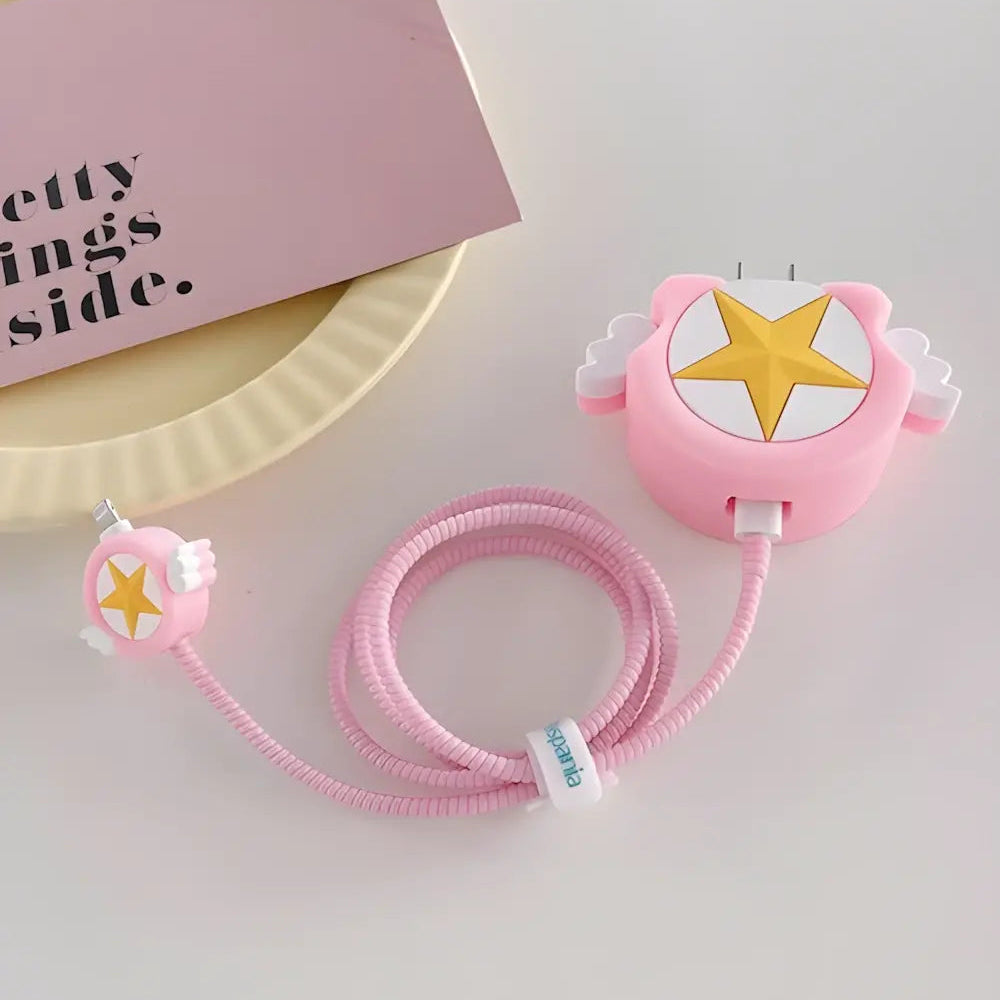 Pink winged star charger cover and mini cable protector with pink spiral cable wrap held up near window with garden background