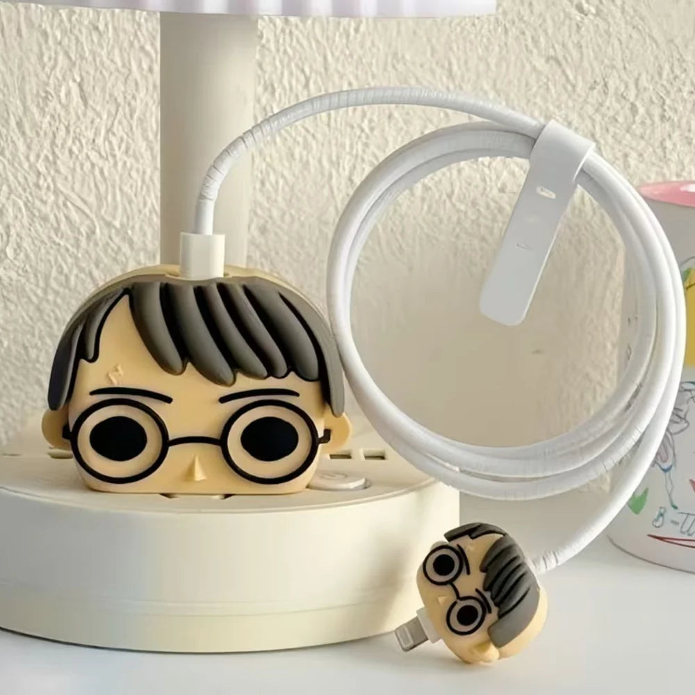 Beige glasses boy wizard charger cover and mini cable protector with white spiral cable wrap on white desk stand next to lamp