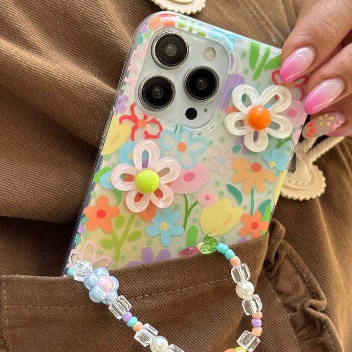 Colorful floral phone case with decorative beads on a brown background