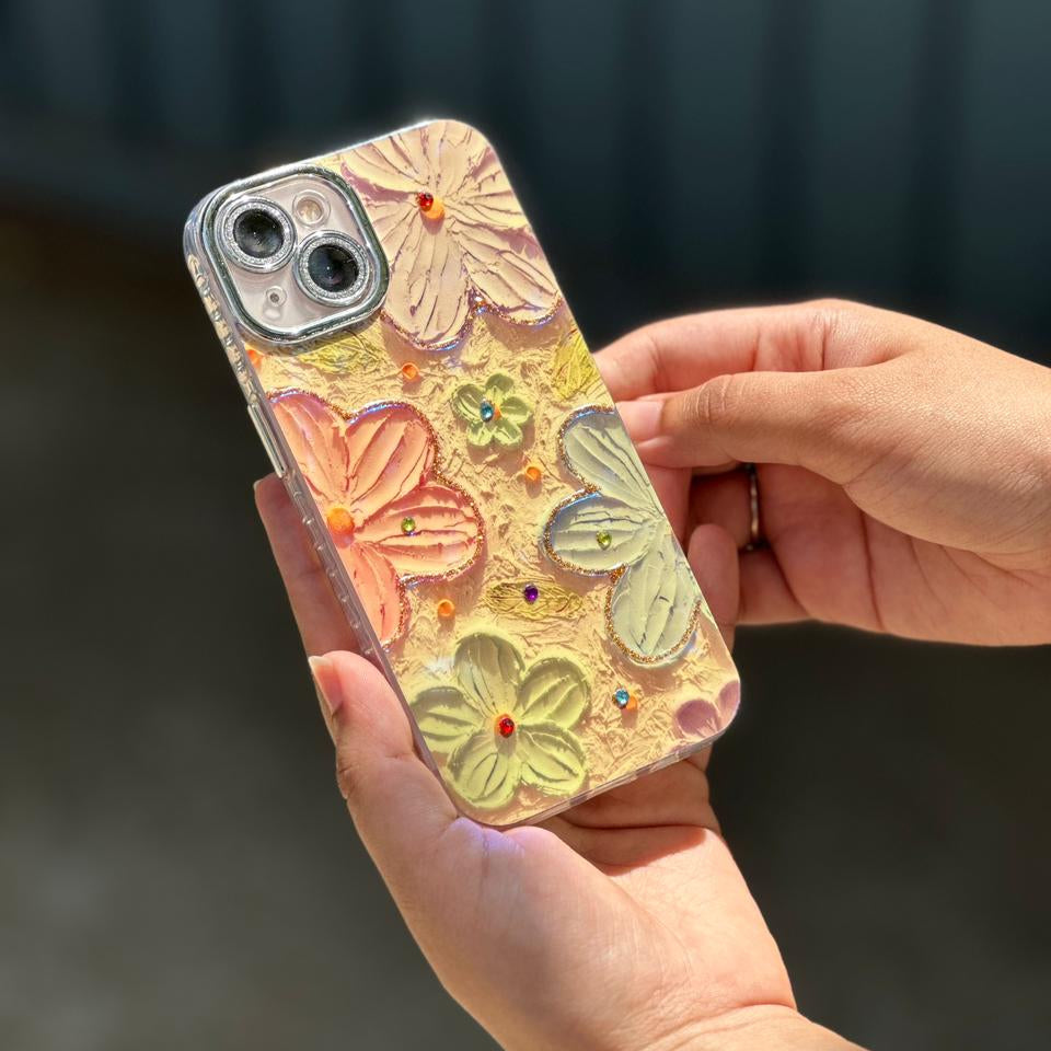 Hand holding a phone case with floral design against a blurred background
