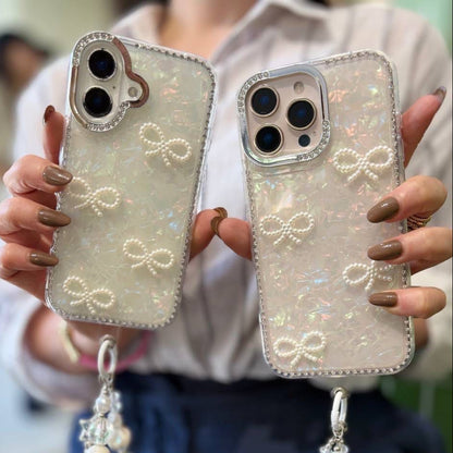 iPouch Pearl Shell Bow iPhone Cases with three crystal bead wristlet chain variants on table