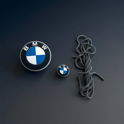 Motorsport roundel charger adapter cover, mini cable protector and spiral cable winder flat lay on white surface