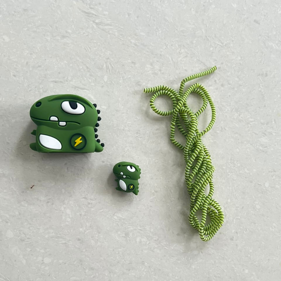 Dino monster charger adapter cover and baby dino cable bite protector with green coil winder on white background