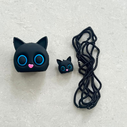 Black cat charger adapter cover, mini cat cable bite and black coil winder - flat lay on white background