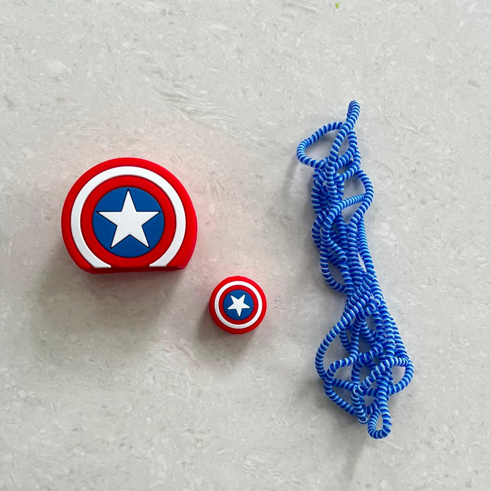 Star shield charger set components - adapter cover, mini cable bite and blue spiral winder on marble surface