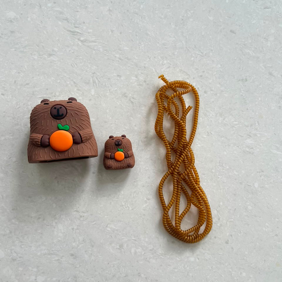 Capybara charger adapter cover, mini capybara cable bite and golden brown coil winder - flat lay components