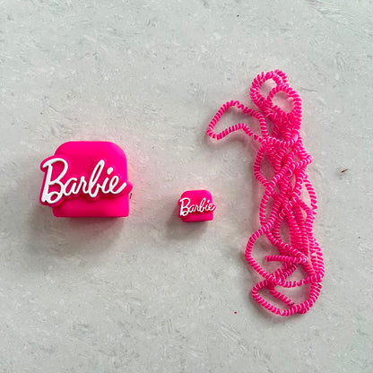 Hot pink silicone charger adapter cover, mini cable protector and spiral cable wrap components laid flat on white surface