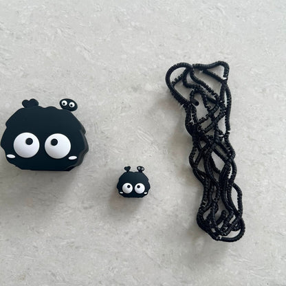Black fluffy spirit charger adapter cover, mini cable protector and black spiral cable wrap components flat lay on grey surface