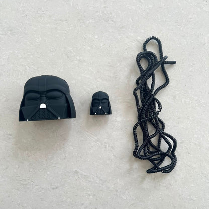 Matte black dark space villain helmet charger cover, mini helmet cable protector and black spiral cable wrap flat lay on grey surface