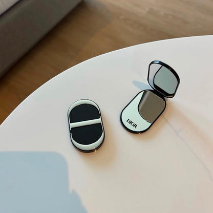 Two monogram compact mirror grips side by side on sofa