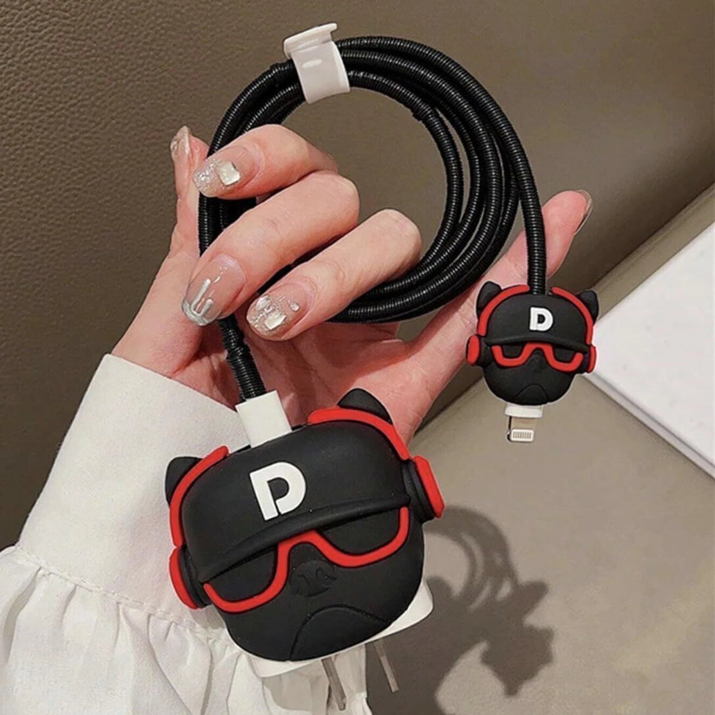 Black and red DJ character charger cover and cable protector set flat lay on white surface