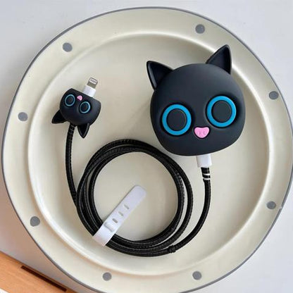 Black cat charger set - adapter cover, mini cat cable bite and black spiral winder on plate - flat lay