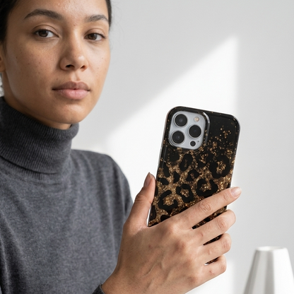 Person holding a phone with a leopard print case in an office setting